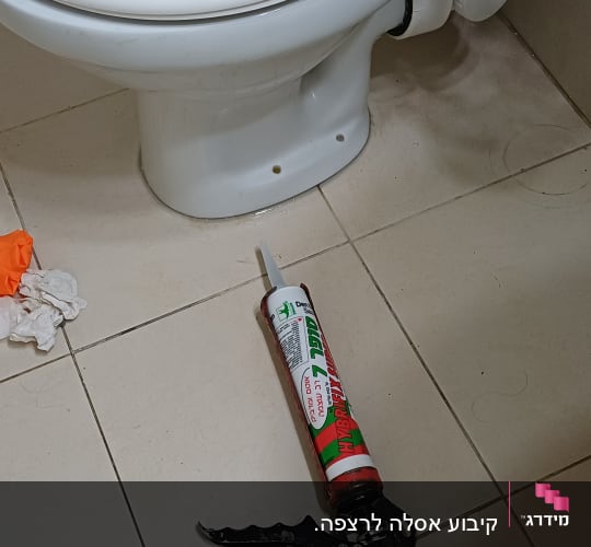 אסלה וכלי עבודה בתחום האינסטלציה על רצפת חדר אמבטיה